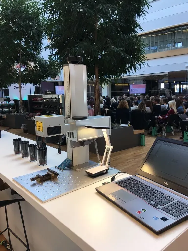 Gravurlaser mit Laptop und vorbereiteten Artikeln auf einer Großveranstaltung